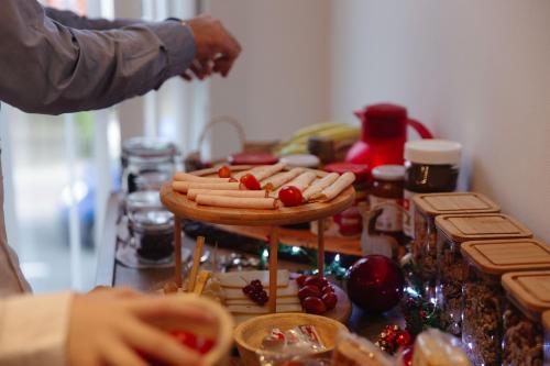 a person reaching for a plate of hot dogs on a table at MD luxury in Bruges