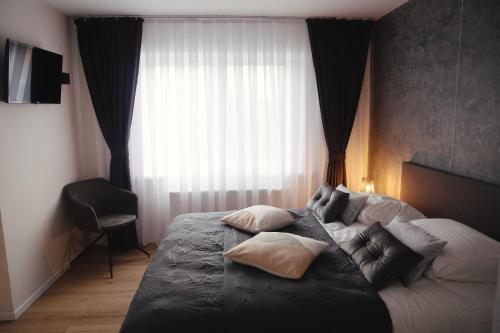 a bedroom with a bed with pillows and a window at MD luxury in Bruges