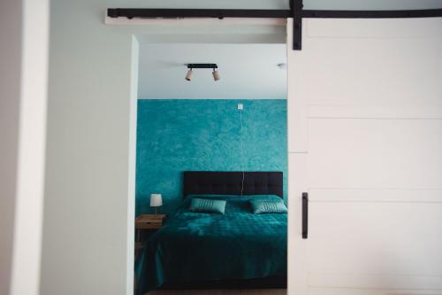 a bedroom with a bed and a blue wall at MD luxury in Bruges