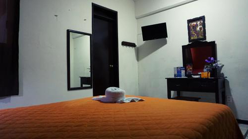 a bedroom with a bed and a dresser and a mirror at Hotel Murallas 231 in Campeche