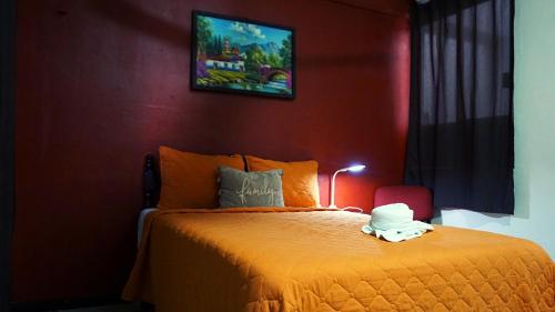 a bedroom with a bed with an orange bedspread at Hotel Murallas 231 in Campeche