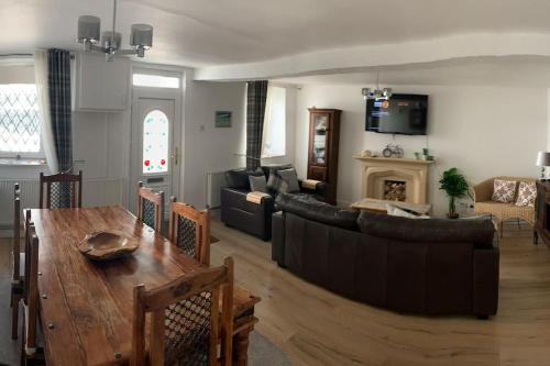 uma sala de estar com um sofá e uma mesa em Cottage nr BikeParkWales/Brecon Beacons/PenYFan em Merthyr Tydfil