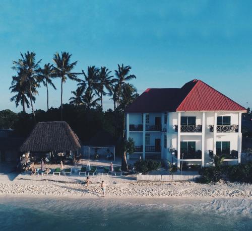 a building on a beach with palm trees and the water at Crystal Beach Nungwi in Nungwi