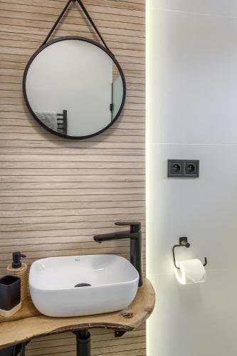 a bathroom with a white sink and a mirror at Apartamenty Dubacik in Tylicz