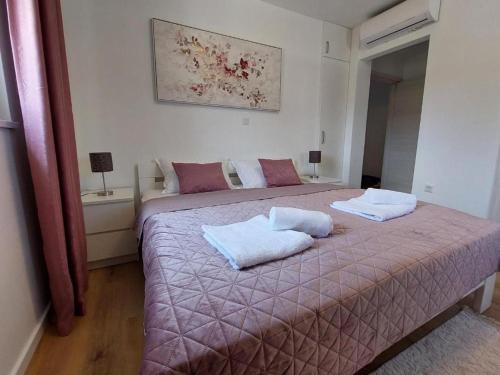 a bedroom with a bed with two pillows on it at Villa Romansa in Malinska