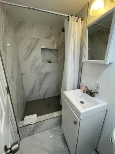 ein weißes Badezimmer mit Waschbecken und Dusche in der Unterkunft Downtown FTL apartments on the River in Fort Lauderdale