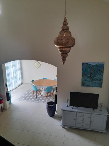 ein Wohnzimmer mit einem Tisch und einem TV in der Unterkunft Chez Marie in La Plaine des Palmistes