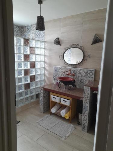 ein Bad mit einem Waschbecken und einem Spiegel in der Unterkunft Chez Marie in La Plaine des Palmistes