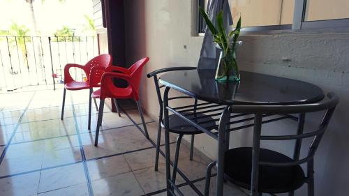 a black table with chairs and a vase with a plant at Hotel Murallas 231 in Campeche