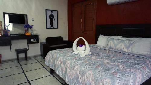 a bed with a cat dressed up in a robe at Hotel Murallas 231 in Campeche