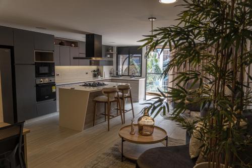 a kitchen with a island and a table with a plant at Luxury Suites Prana By Cadissa in Medellín