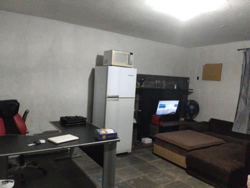 een woonkamer met een koelkast en een bank bij Hostel família Campineira in Campinas