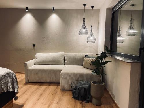 a living room with a couch and pendant lights at Apartments Riese in Neustift im Stubaital