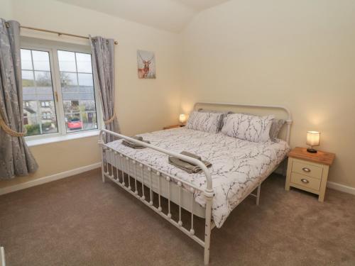 1 dormitorio con cama y ventana en Quarry Cottage, en Buxton