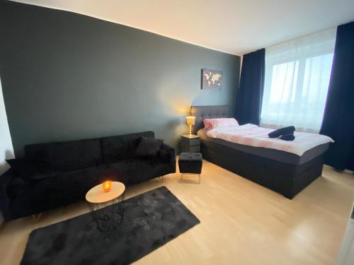 a living room with a bed and a couch at Moderne Wohnung Nähe Hauptbahnhof Linz in Linz