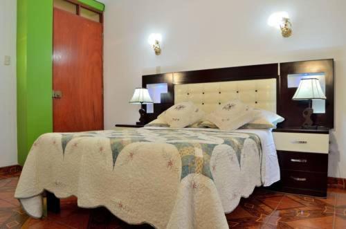 1 dormitorio con 1 cama grande y 2 lámparas en Hostal Mansion Dorada, en Tacna