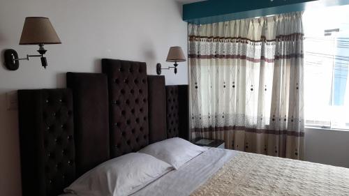 Un dormitorio con una cama grande y una ventana en Hostal Mansion Dorada, en Tacna