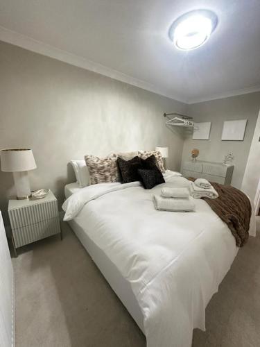 een slaapkamer met een groot wit bed met kussens bij Seahaven in Sandbanks in Poole