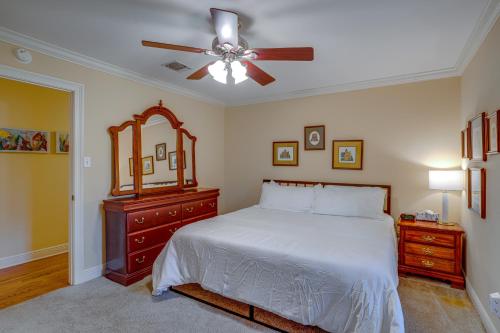 a bedroom with a bed with a ceiling fan and a mirror at Yellow Adirondack Hideaway in Gulfport