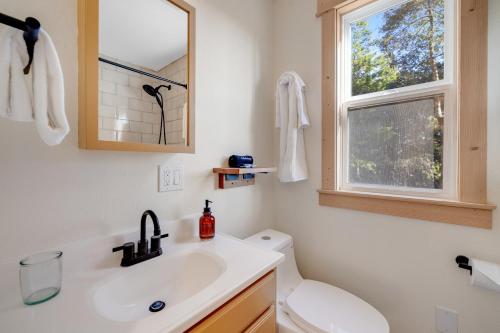 baño con lavabo y aseo y ventana en Mendocino Redwood Retreat - Sunrise Cottage, en Albion