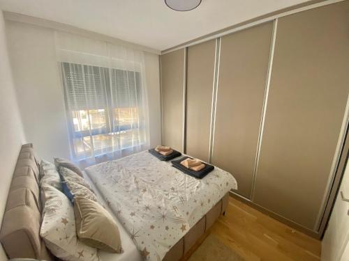 a small bedroom with a bed and a window at Apartment Llama in Trebinje