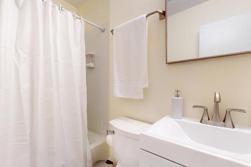 La salle de bains blanche est pourvue d'un lavabo et de toilettes. dans l'établissement Market Street Memories, à Frederick