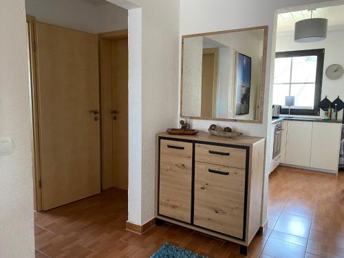 a room with a dresser with a mirror and a kitchen at Grömitz, Stiegkamp 3, Whg 2 - große Wohnung mit Balkon, 2 SZ, Nähe Yachthafen und Strand, inkl WLAN in Grömitz