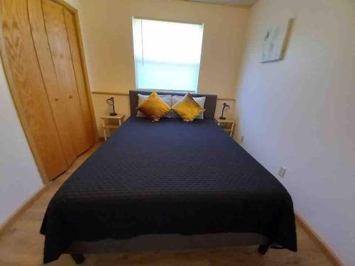 um quarto com uma cama preta e almofadas amarelas em Ottawa's Finest - Located Close to Downtown! em Ottawa