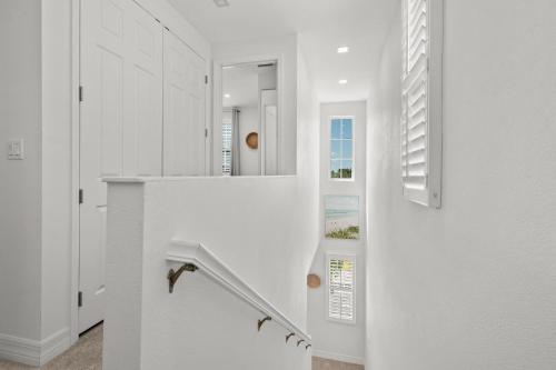 Una escalera blanca en una casa con espejo en Sea Salt at Hunter's Point, en Cortez