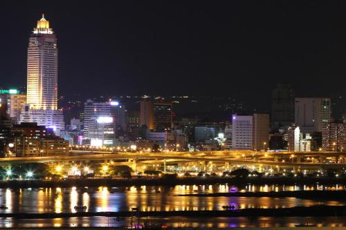 a city skyline at night with a bridge and a river at Wemeet Hotel Taipei in Taipei
