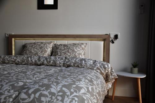 a bed with a gray and white comforter and a table at A Muralha in Porto