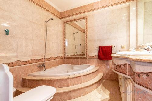 a bathroom with a tub and a toilet and a sink at Casa grande piscina y garaje in Aljaraque