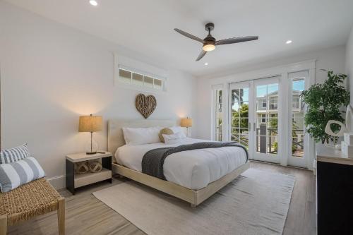 um quarto branco com uma cama e uma ventoinha de tecto em Sweet and Salty em Holmes Beach