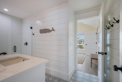 uma casa de banho branca com um lavatório e um chuveiro em Sweet and Salty em Holmes Beach
