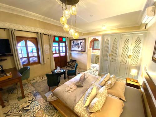 een slaapkamer met een bed en een tafel en stoelen bij Riad La Perle Rouge in Marrakesh