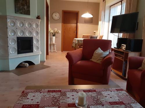 a living room with two chairs and a fireplace at FeWo Lüneburger Heide - Minni in Bad Bevensen