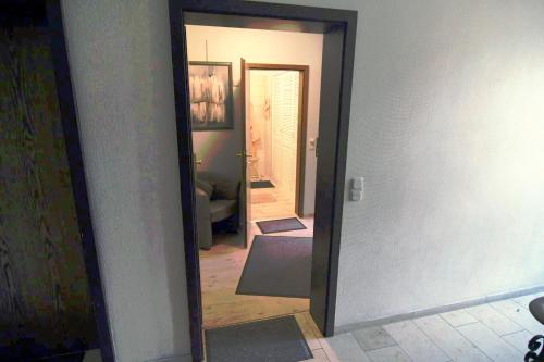 a hallway with a mirror looking into a room at FeWo Lüneburger Heide - Minni in Bad Bevensen