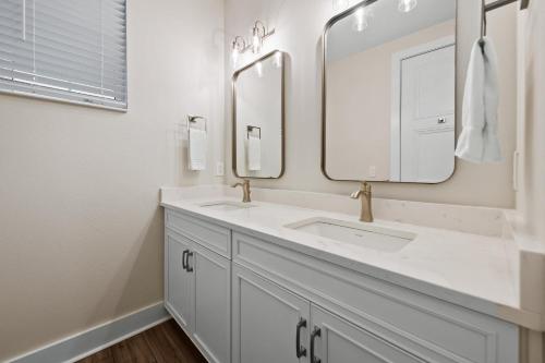 a bathroom with two sinks and two mirrors at Salty Seagull at Hunter's Point in Cortez