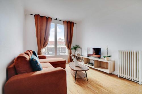 a living room with a couch and a table at Cozy 2-Bedroom Apartment in the Heart of Suresnes in Suresnes