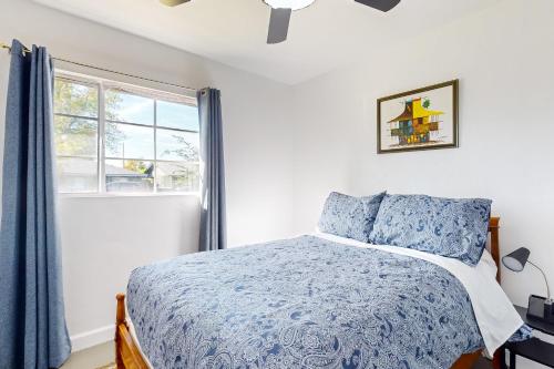 a bedroom with a blue bed and a window at The Desert Brickstone in Phoenix