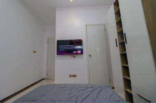 a bedroom with a bed and a tv on the wall at Chic sanctuary & tranquil oasis in Lekki