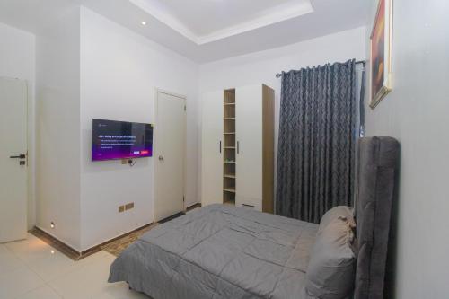 a bedroom with a bed and a flat screen tv at Chic sanctuary & tranquil oasis in Lekki