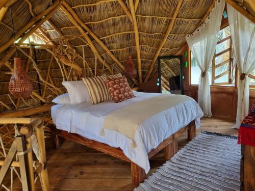 1 dormitorio con 1 cama en un techo de bambú en El Manguito en Sayulita