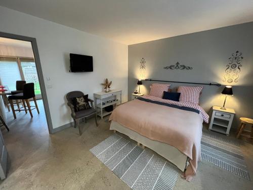 une chambre avec un lit, une télévision et une table dans l'établissement GSand Le Clos du May, à Le Poinçonnet