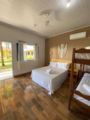 a bedroom with a white bed and a window at Quintal da Praia in Prado
