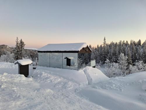 un edificio ricoperto di neve con alberi sullo sfondo di SPEGILL ad Aurdal