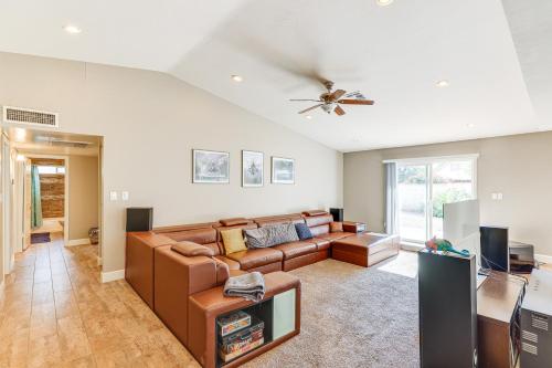 a living room with a couch and a ceiling fan at 12 Mi to Old Town! Home with Furnished Patio in Phoenix