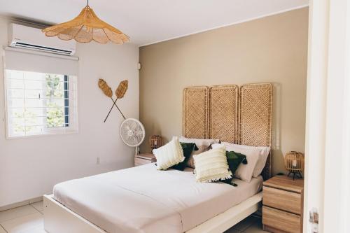 een slaapkamer met een groot wit bed met kussens bij Paradiso Chikitu Little Paradise in Willemstad