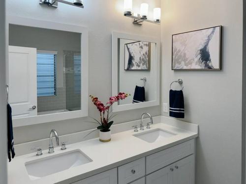 a bathroom with two sinks and two mirrors at Downtown Houston Haven in Houston
