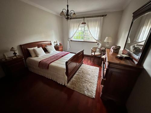 a bedroom with a bed and a desk and a window at Oliveiras in Canedo